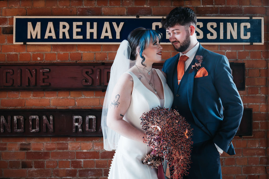 Couple portrait in an industrial museum with vintage metal signs in the background