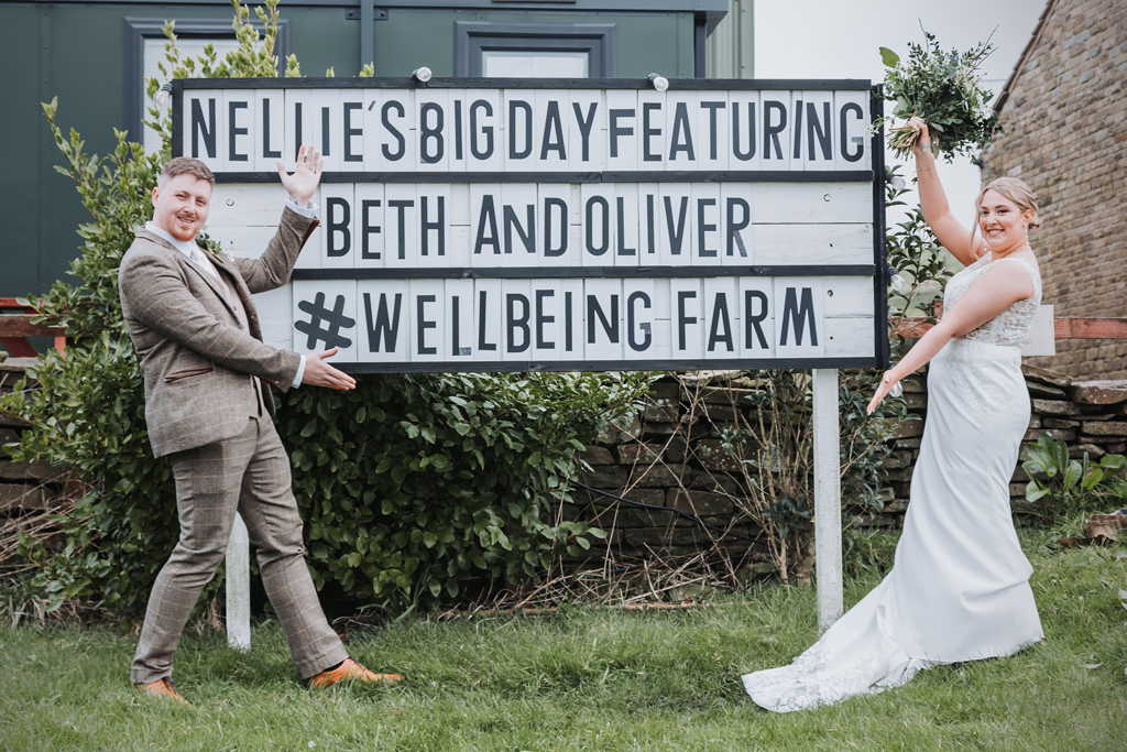 newlyweds post with a personalised holywood sign at the wellbeing farm wedding venue in lancashire