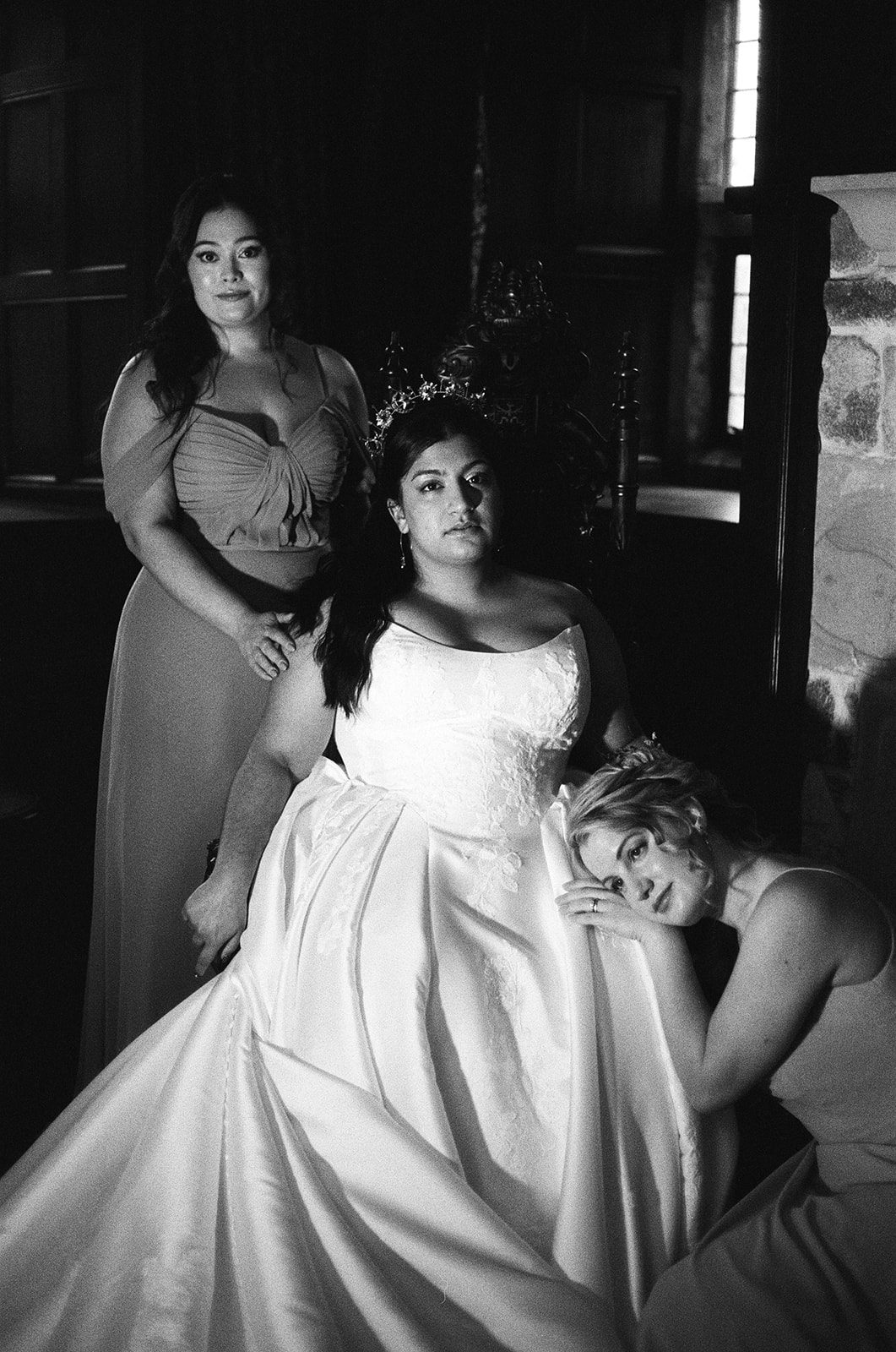 black and white photograph of a bride wearing white dress and celestial crown with two bridesmaids