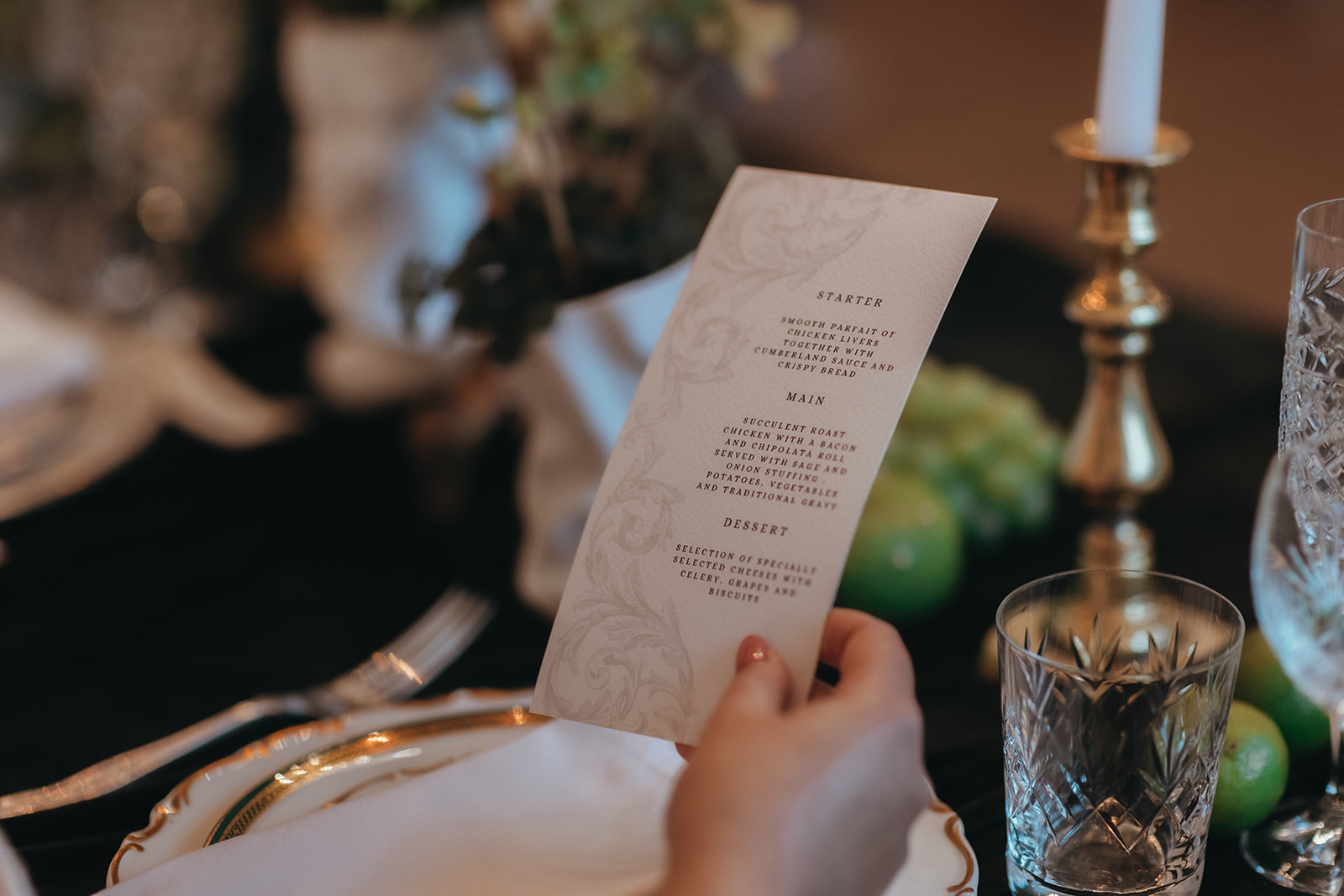 detail shot of a renaissance inspired wedding menu being held