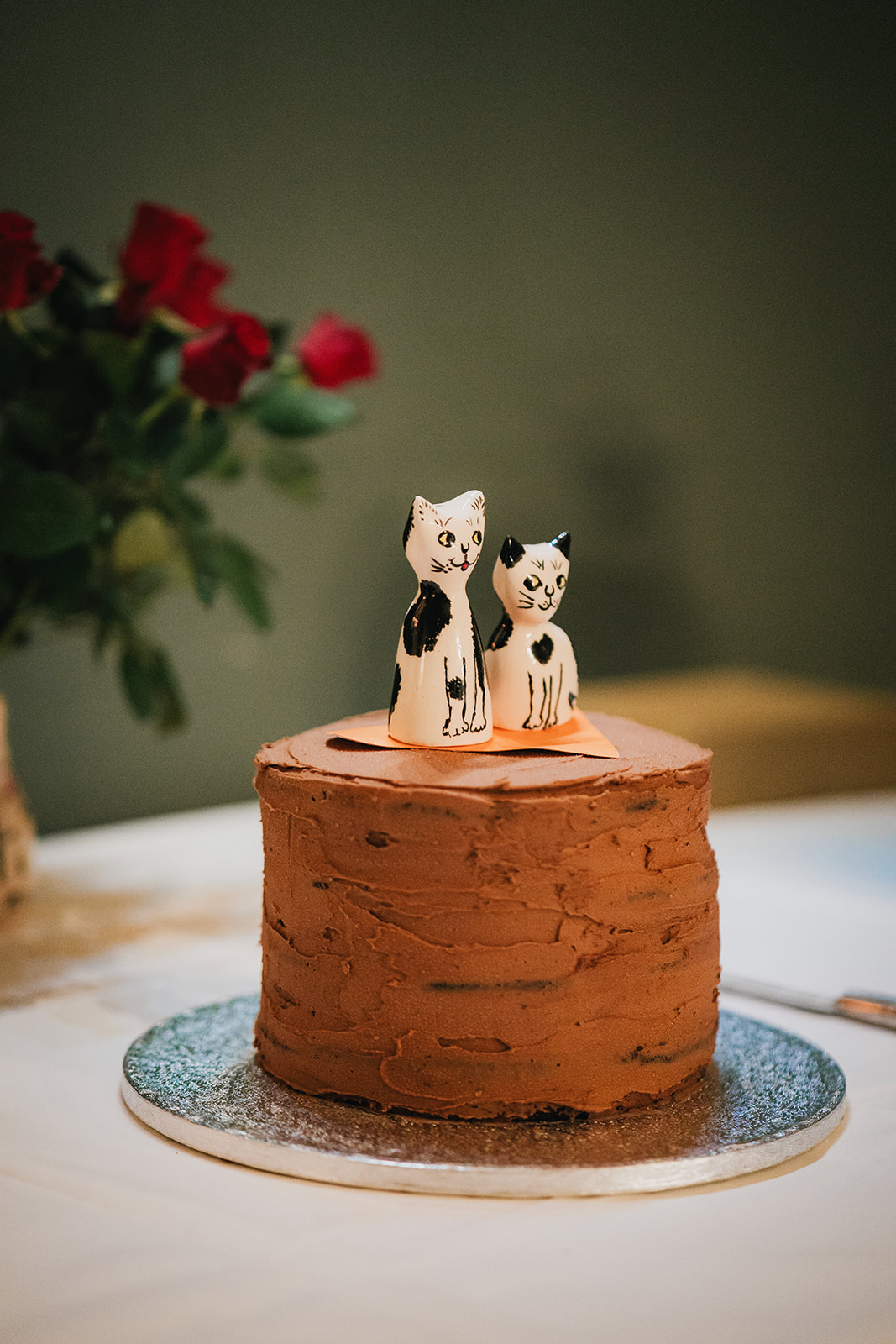 detail shot of handmade wedding cake with cat salt and pepper toppers made by a family member