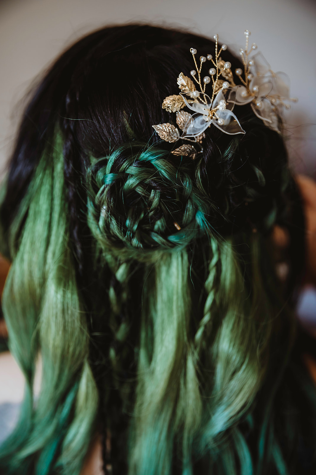 detail shot of the brides green hair arranged in viking braids