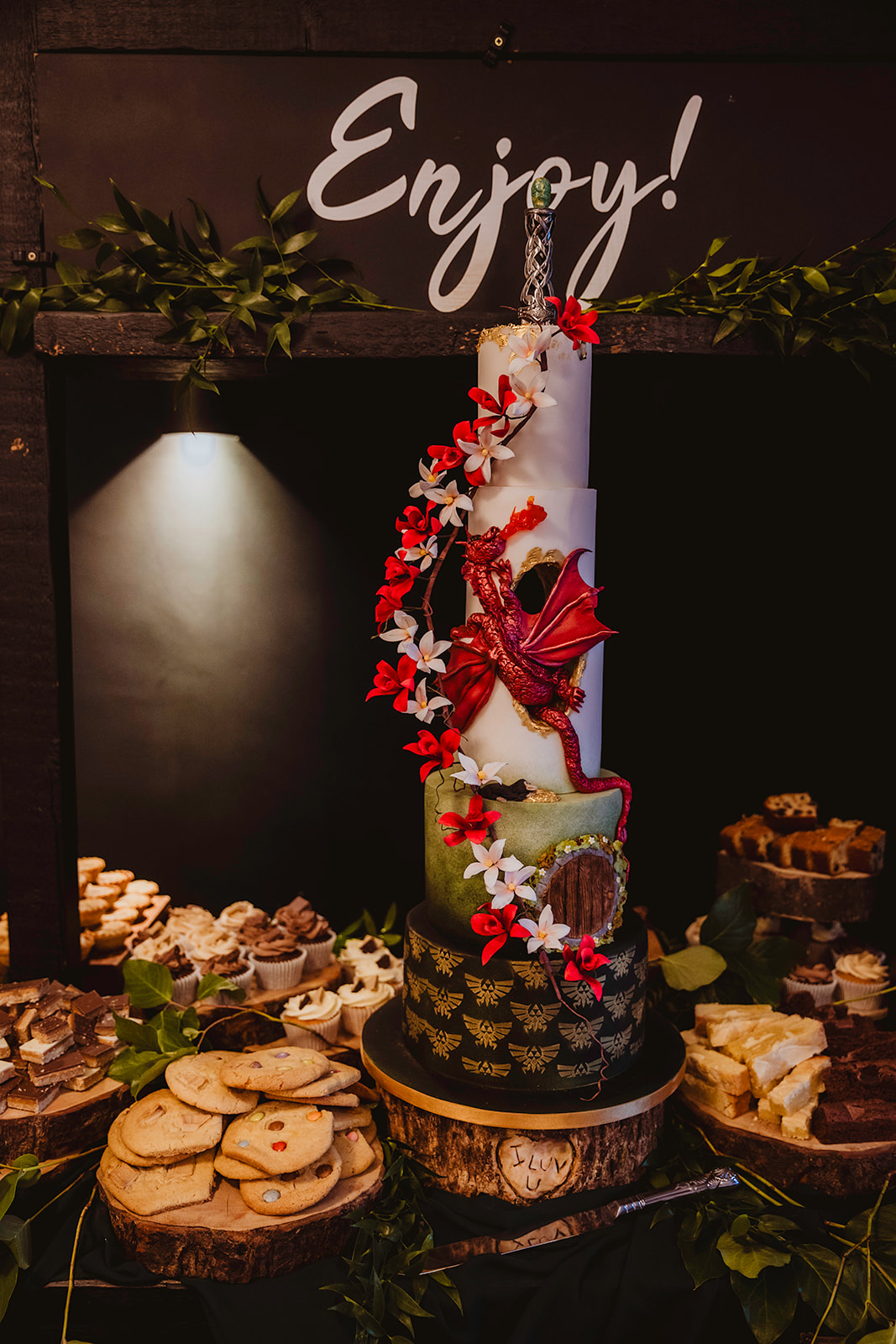 photo of a 6 tiered wedding cake with dragon and sharing desert table all displayed on wooden stands