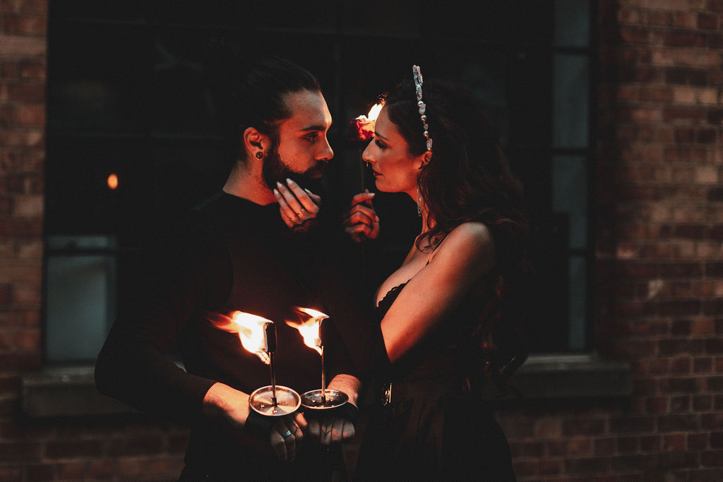 couple embracing during a fire performance as part of a dark romance edgy wedding