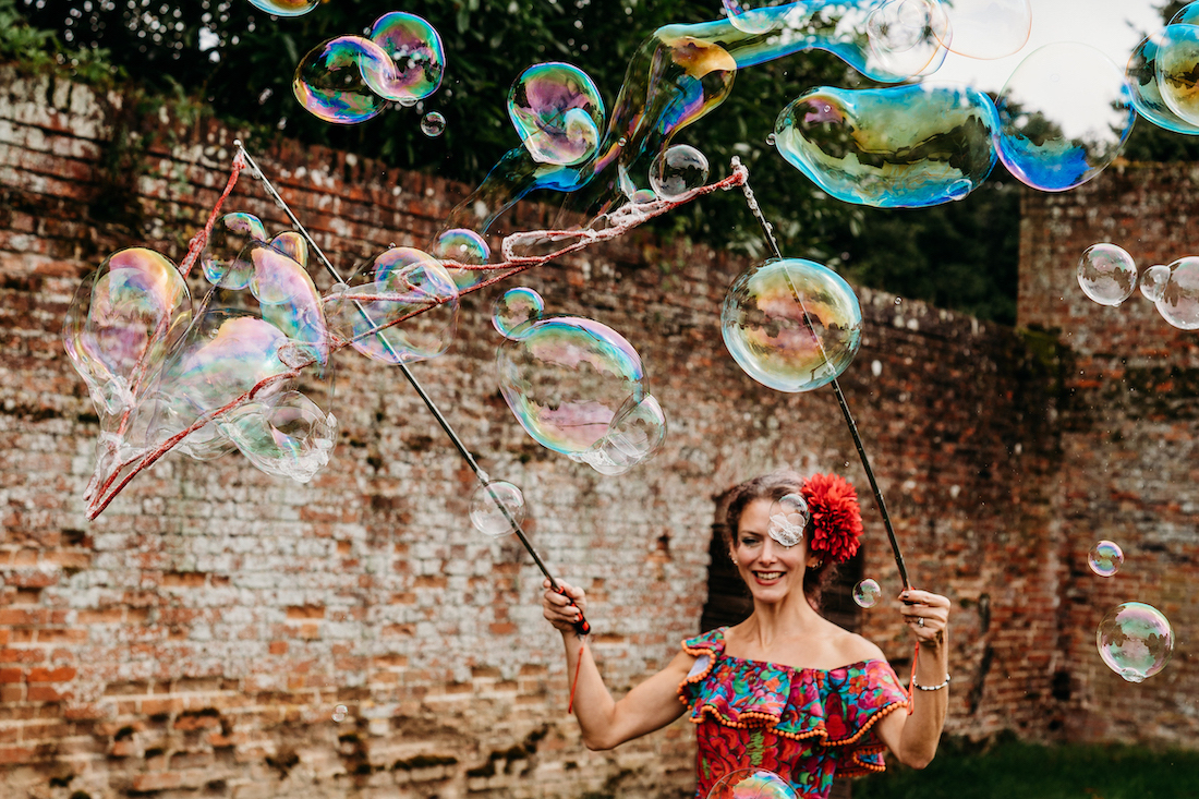 Circus performer blowing huge bubbles as part of festival wedding outdoor entertainment