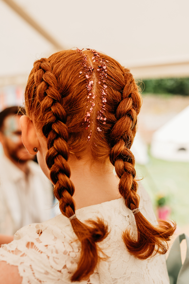 detail shot of glitter in a flower girls hair at a festival wedding