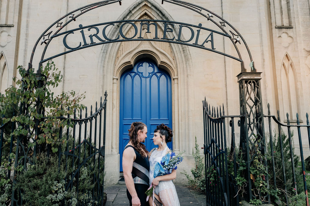 bride and groom stood under 'circomedia' entrance arch