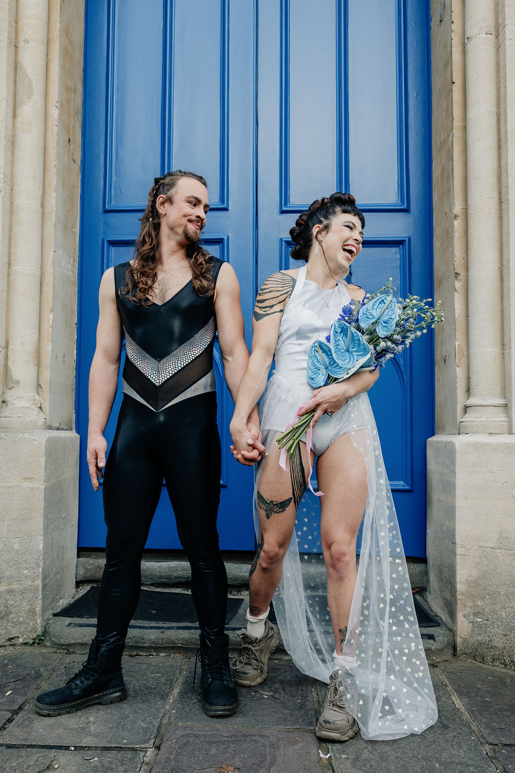 bride and groom wearing performance jumpsuits outside of their circus wedding venue