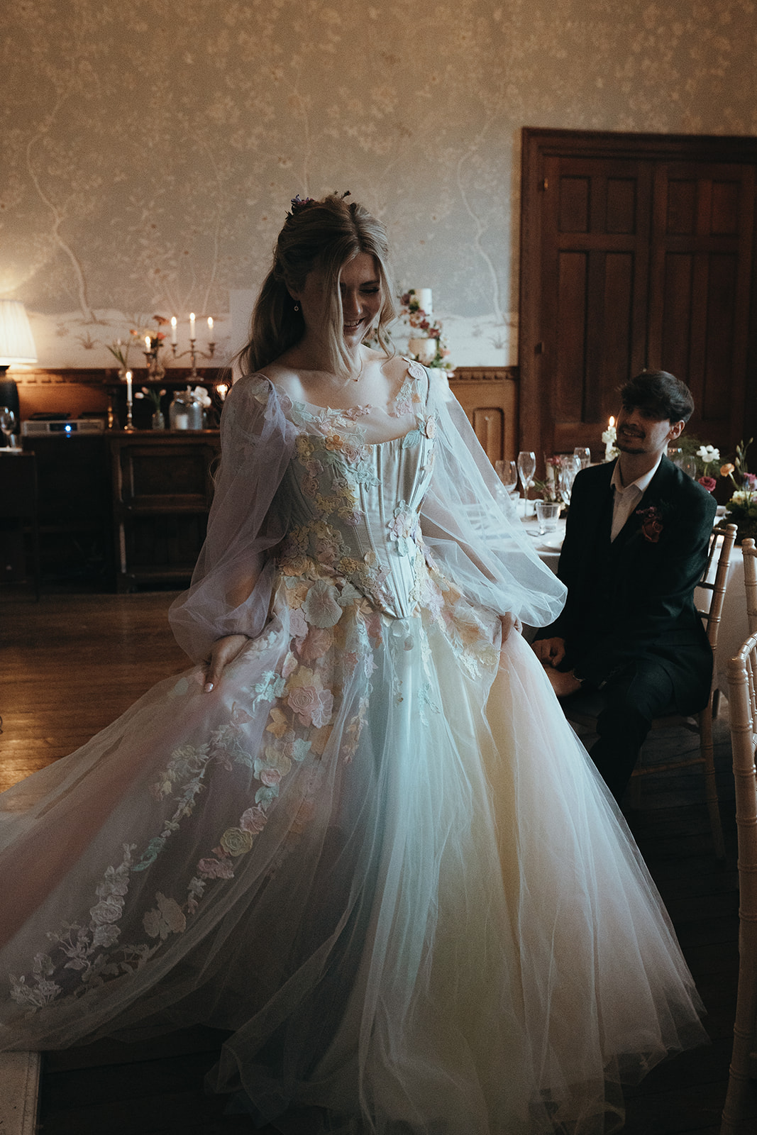 bride wearing pastel coloured corseted tule wedding dress covered with fabric flowers
