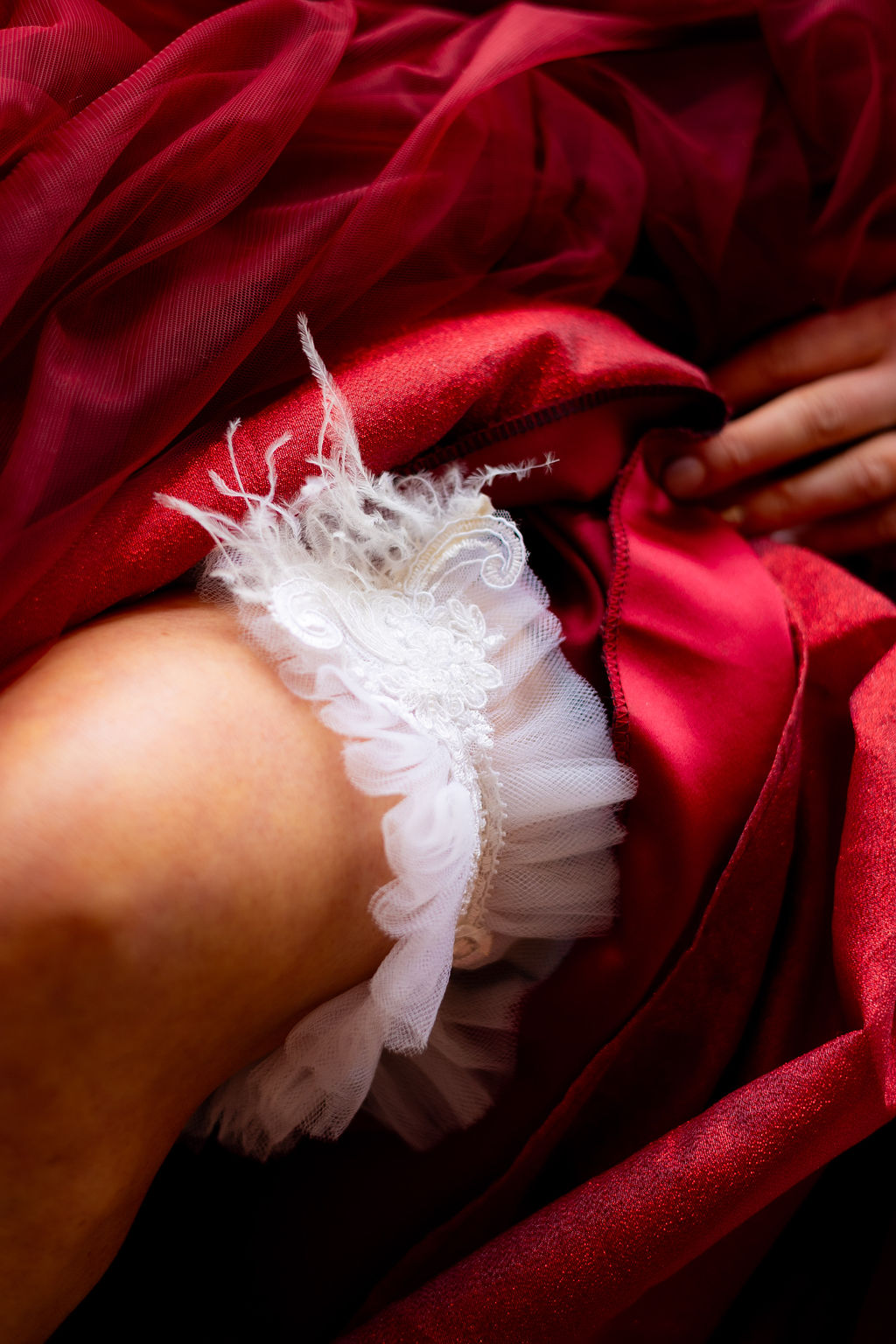 detail shot of a tule, lace and feather wedding garter