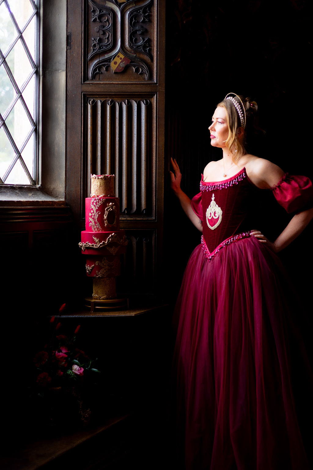 atmospheric photo of a bride and wedding cake surrounded by carved wood walls of a castle