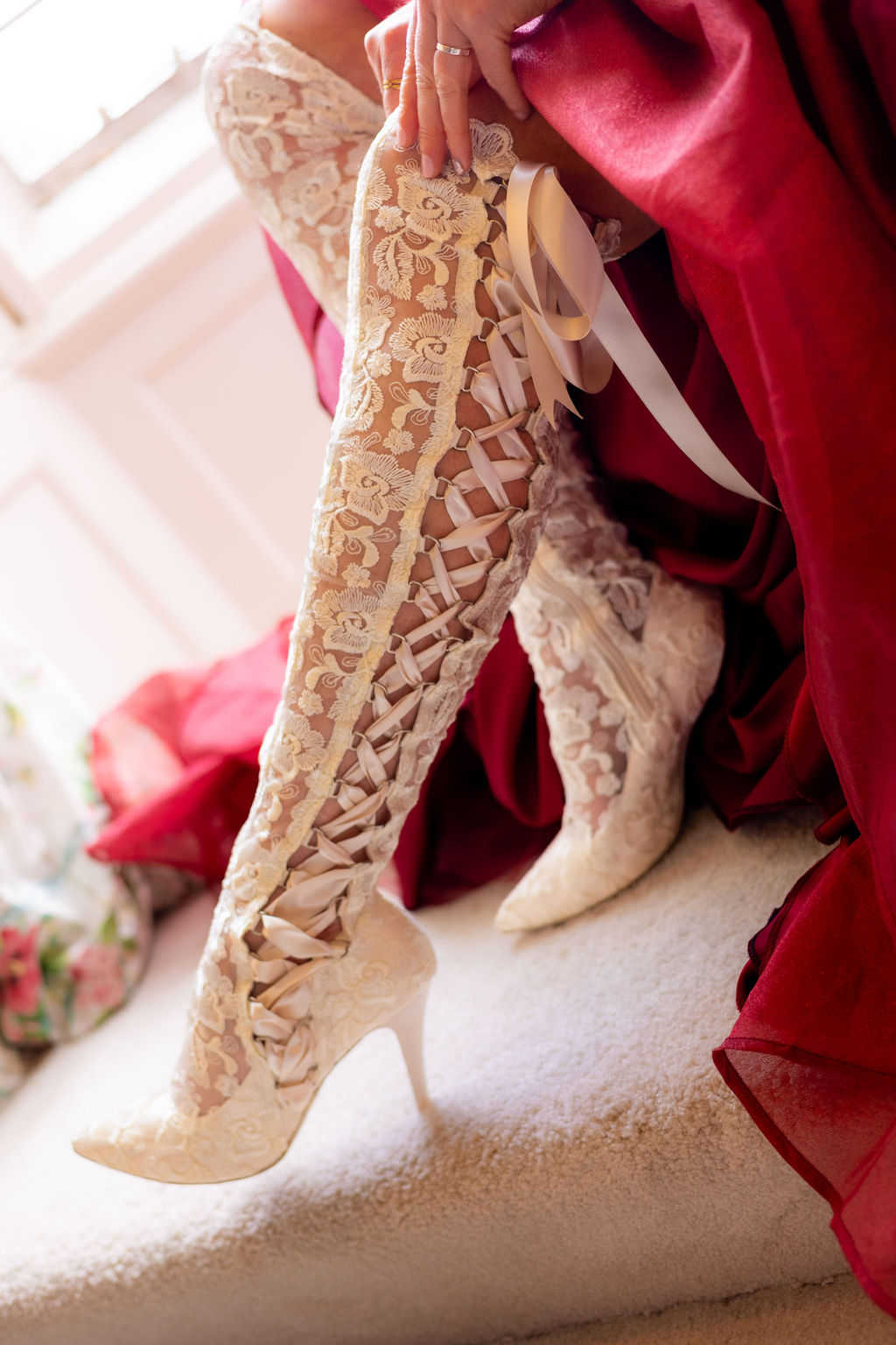 detail shot of lace over the knee wedding boots being pulled up