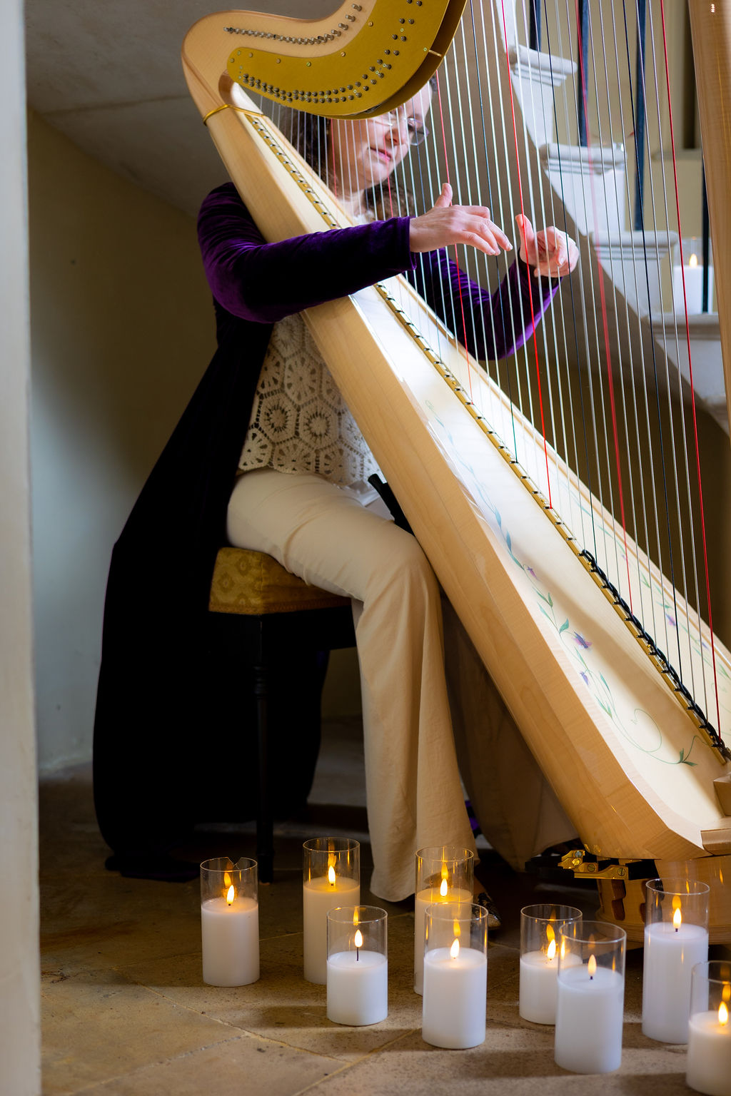 Woman playing the harp for atmospheric Pre-Raphaelite inspired wedding in historical Devon wedding venue