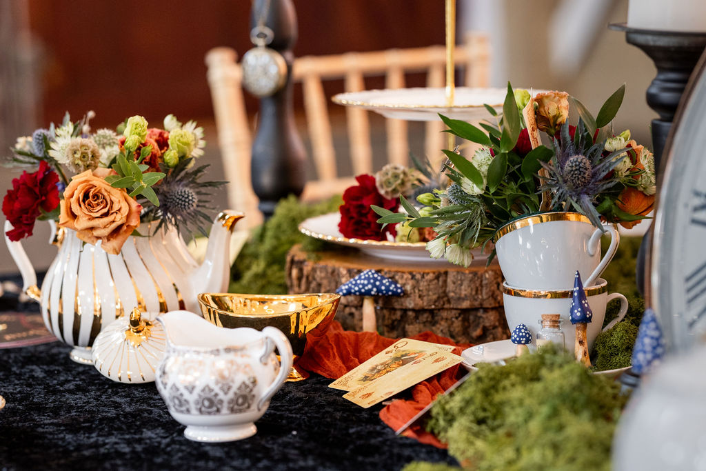 detail shot of vintage cups and teapots filled with flowers