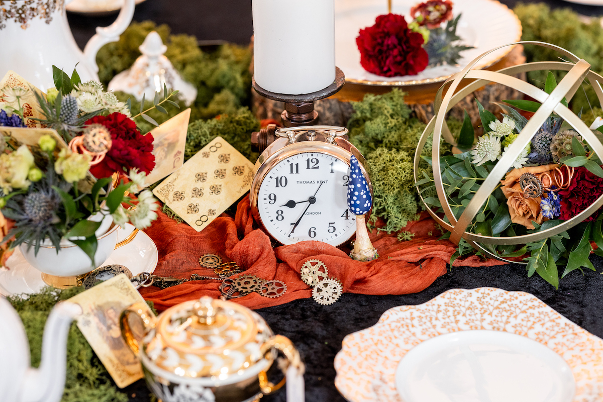 detail shot of wedding breakfast table covered in cogs, keys, clocks and vintage playing cards