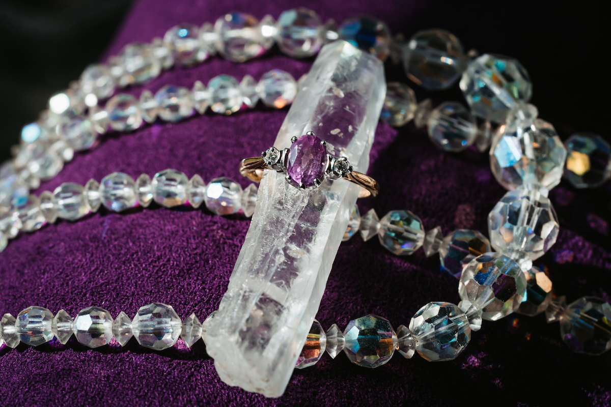 amethyst and diamond engagement ring set on a piece of quartz
