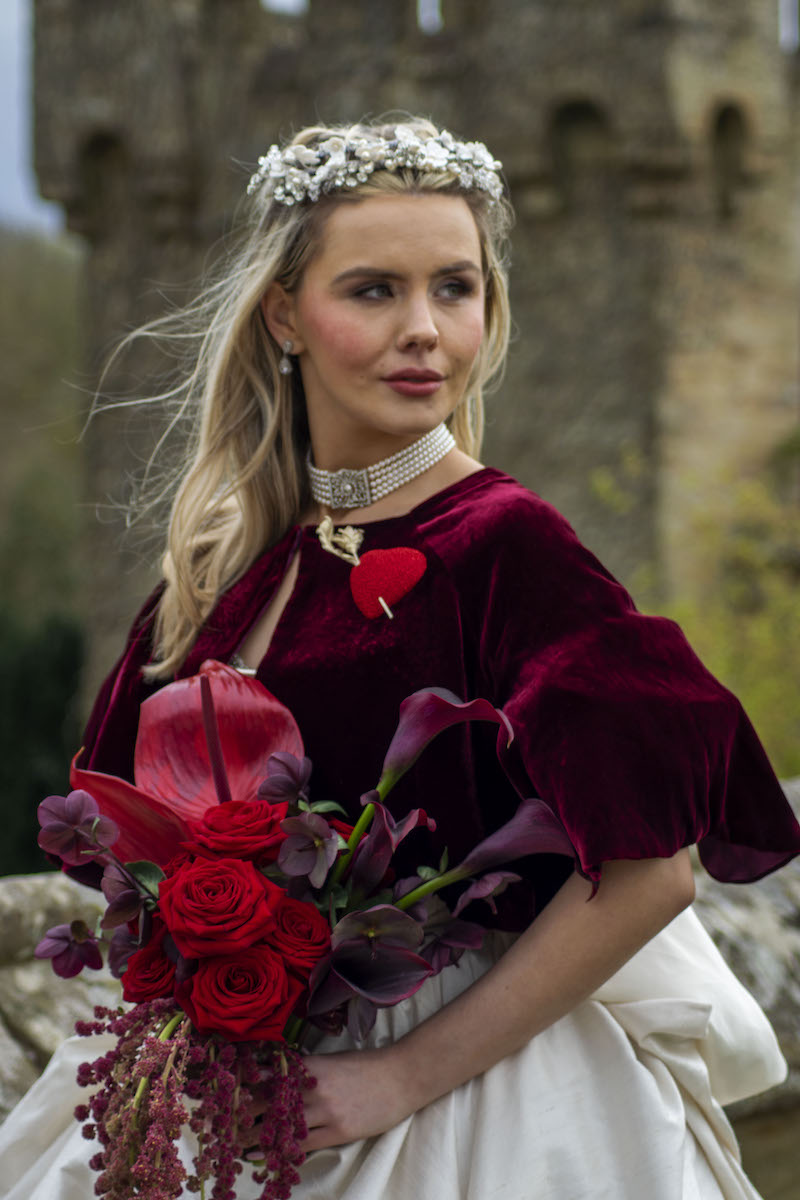 bride wearing a deep red velvet cape for Wuthering Heights inspired wedding