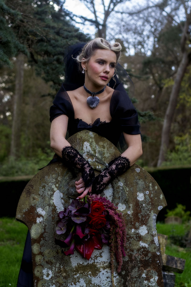 Wuthering Heights inspired bridal portrait where the bride is posed over a grave stone.