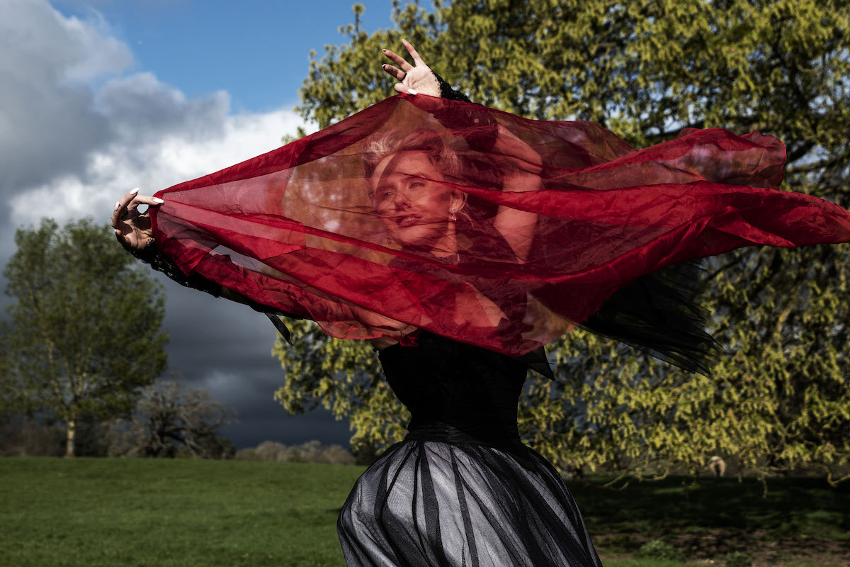 Wuthering Heights inspired bridal portrait with bride wearing black wedding dress, holding red scarf for final scenes