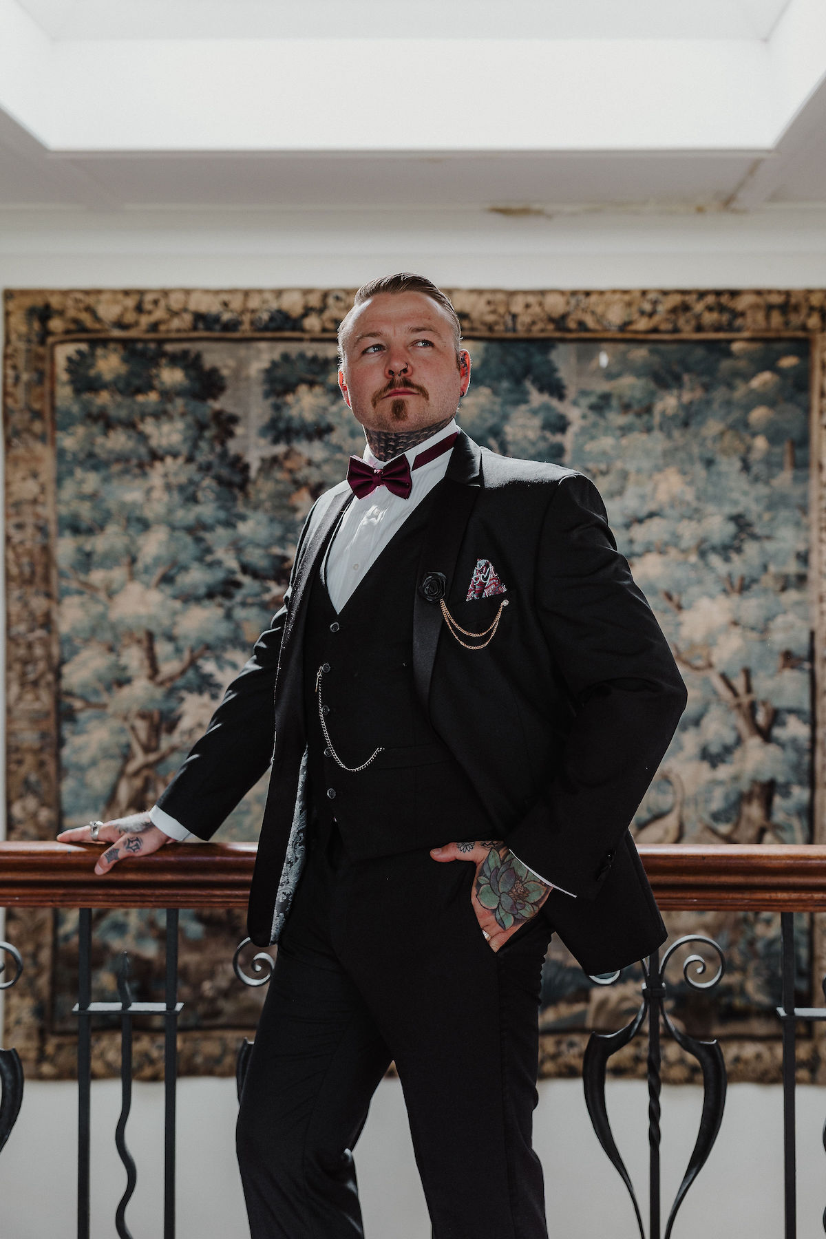 portrait of a groom wearing a three piece suit and bow tie with pocket watch
