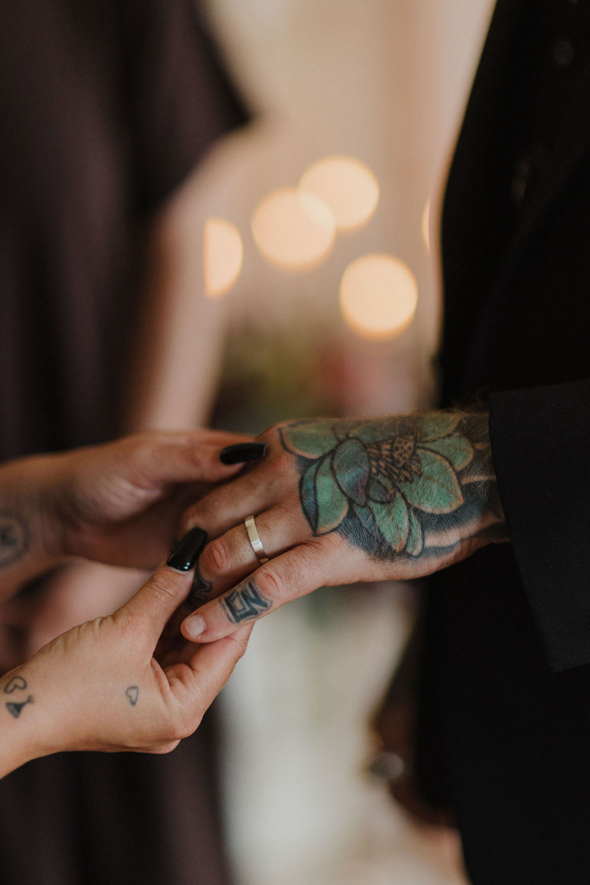 close up of bride placing a handmade wedding ring on her grooms finger during a Cornwall wedding