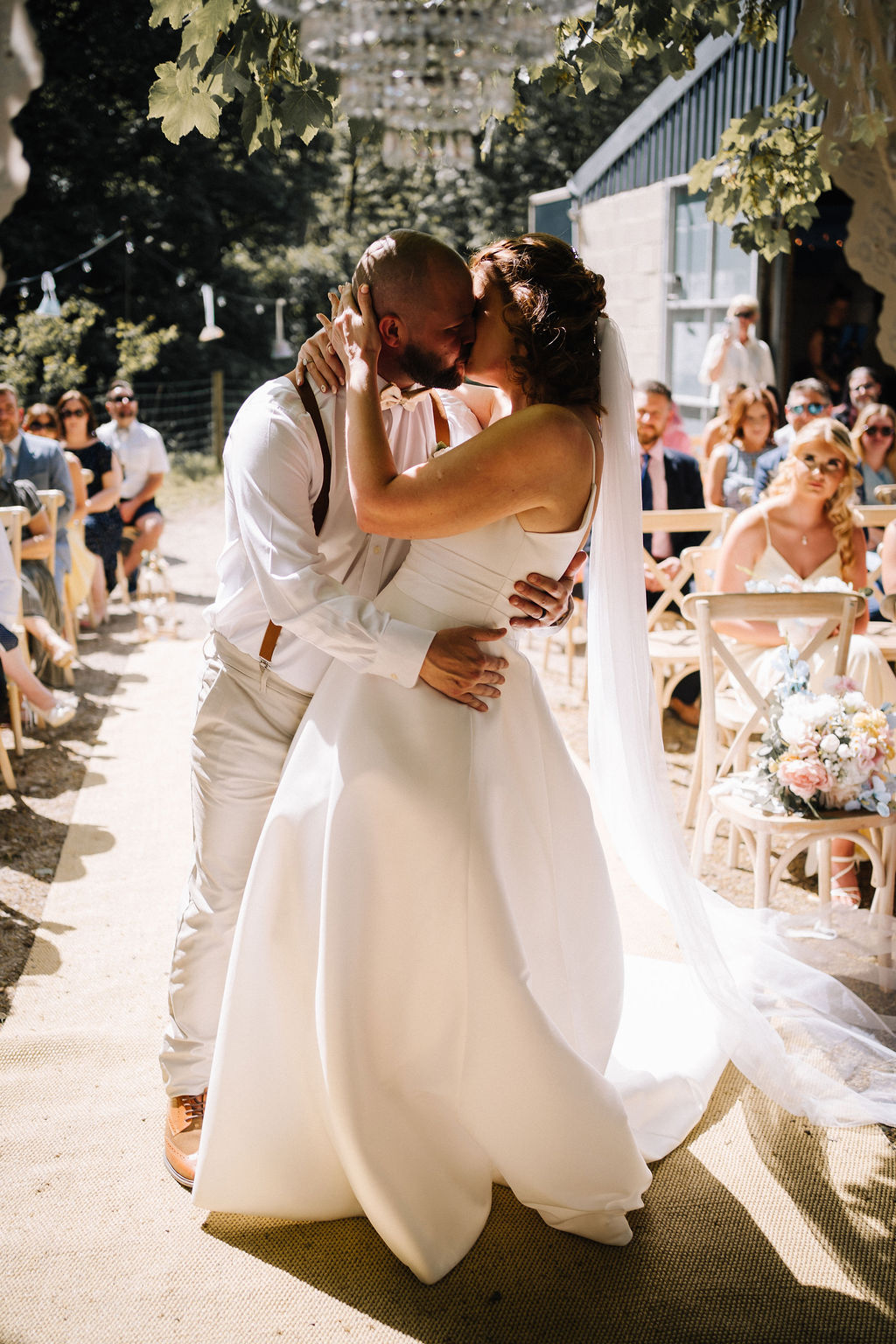 bride and groom kissing at their outdoor wedding ceremony
