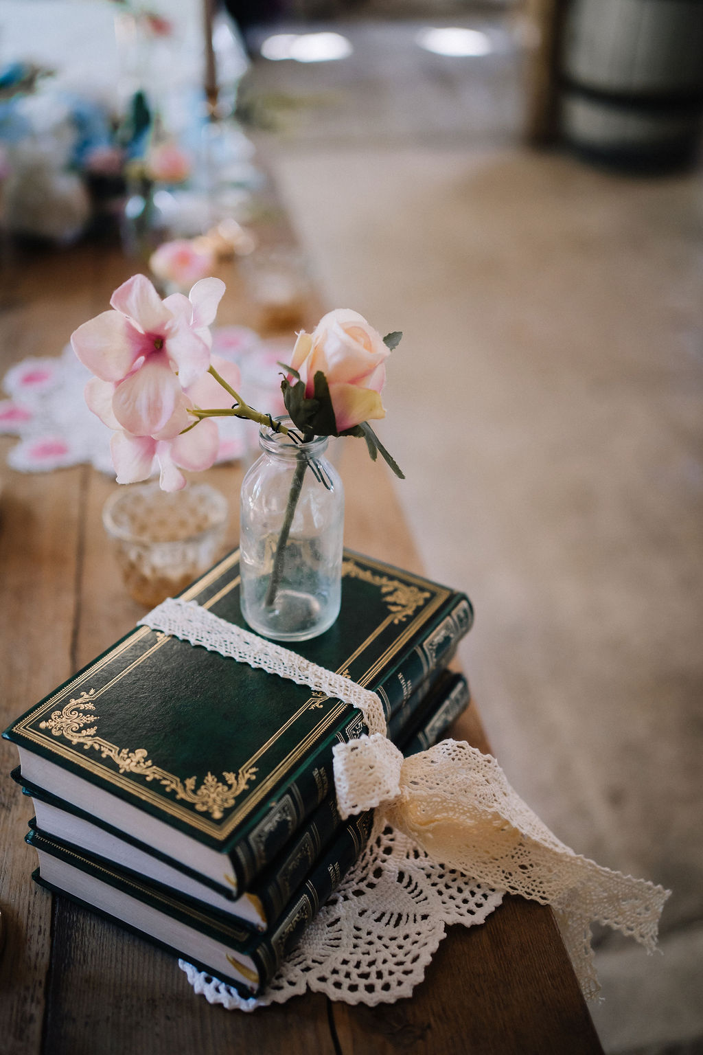 old books wrapped in lace with bud vase for vintage style DIY table decor