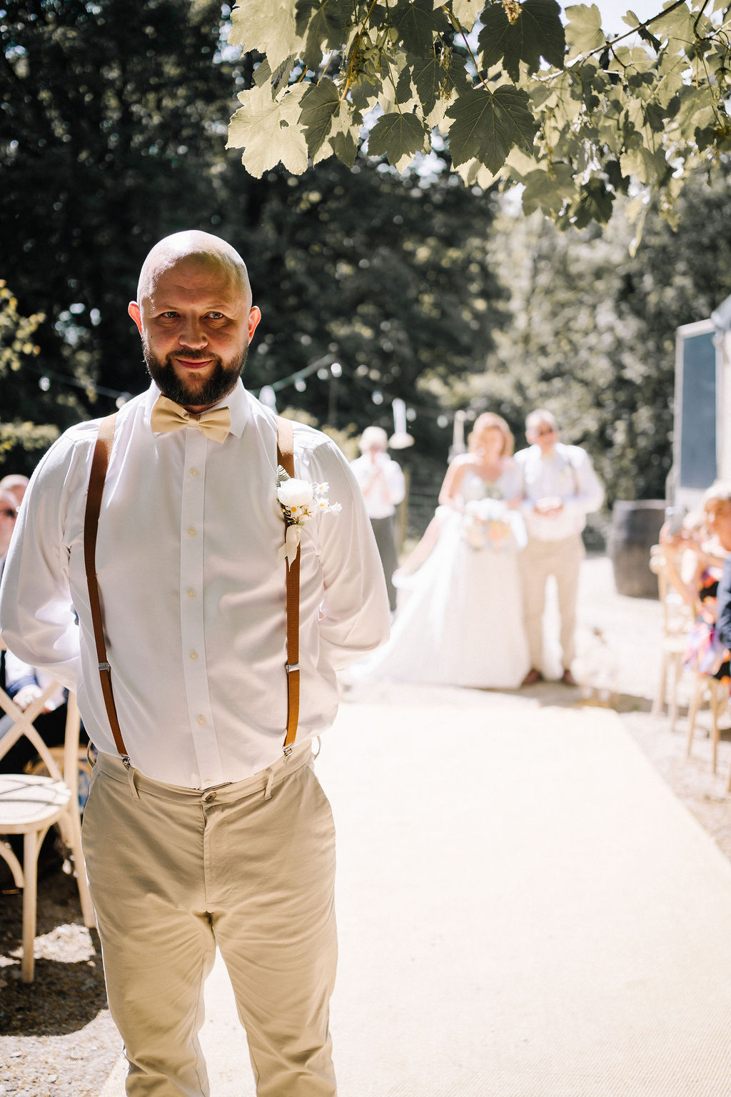 groom waiting for the bride to walk down the aisle of their outdoor wedding ceremony