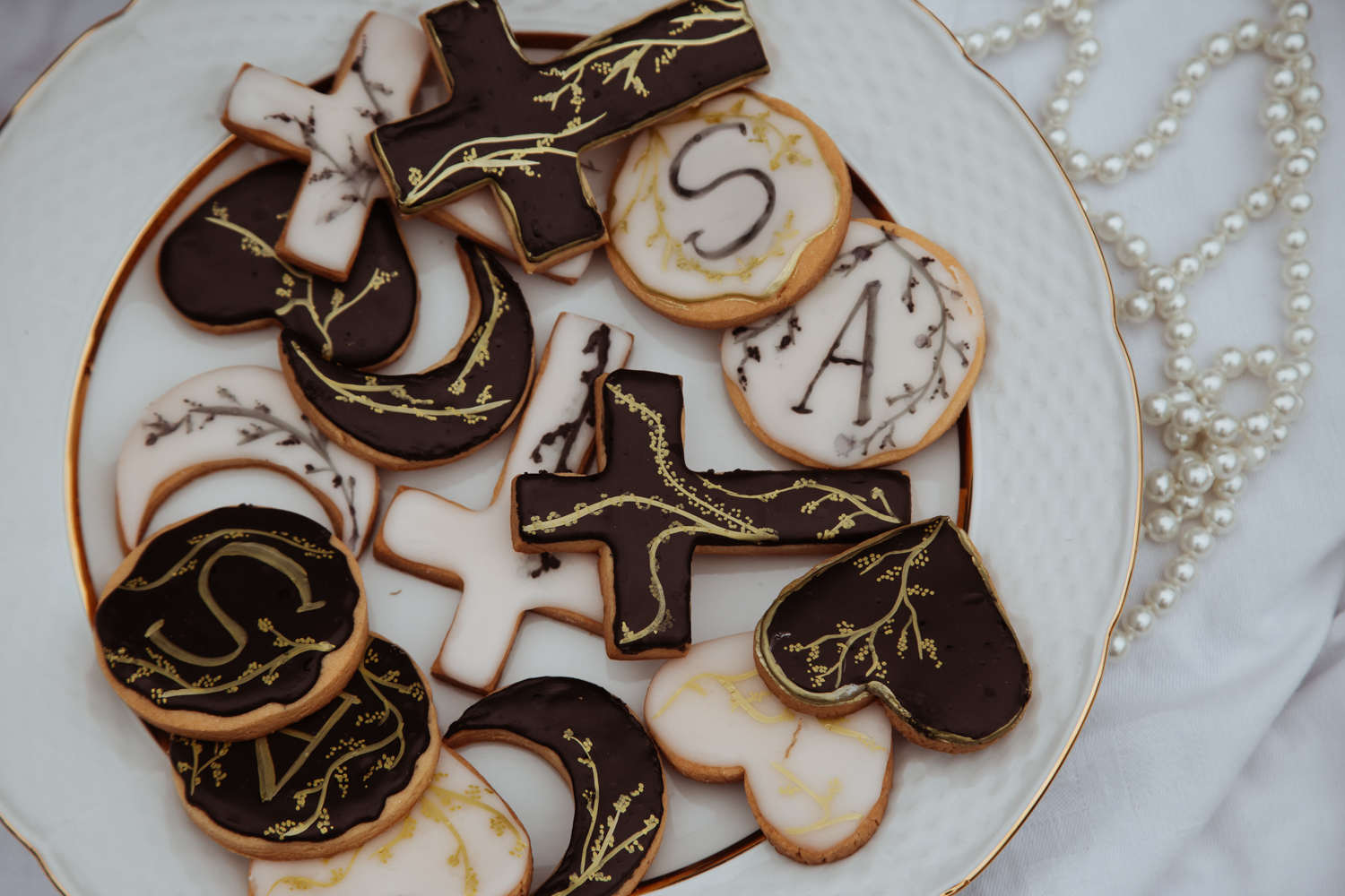 close up of hand made biscuits topped with icing and painted with gold motifs