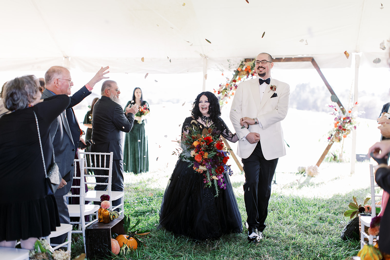 newly weds walking back down the aisle as friends and family throw confetti