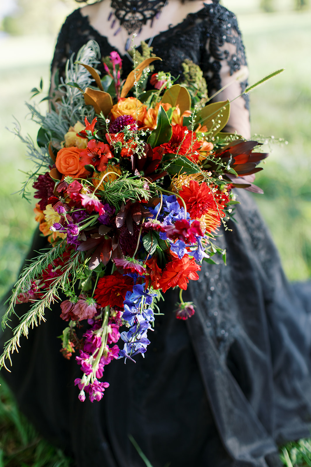 statement wedding bouquet made with red, purple, orange and deep pink flowers