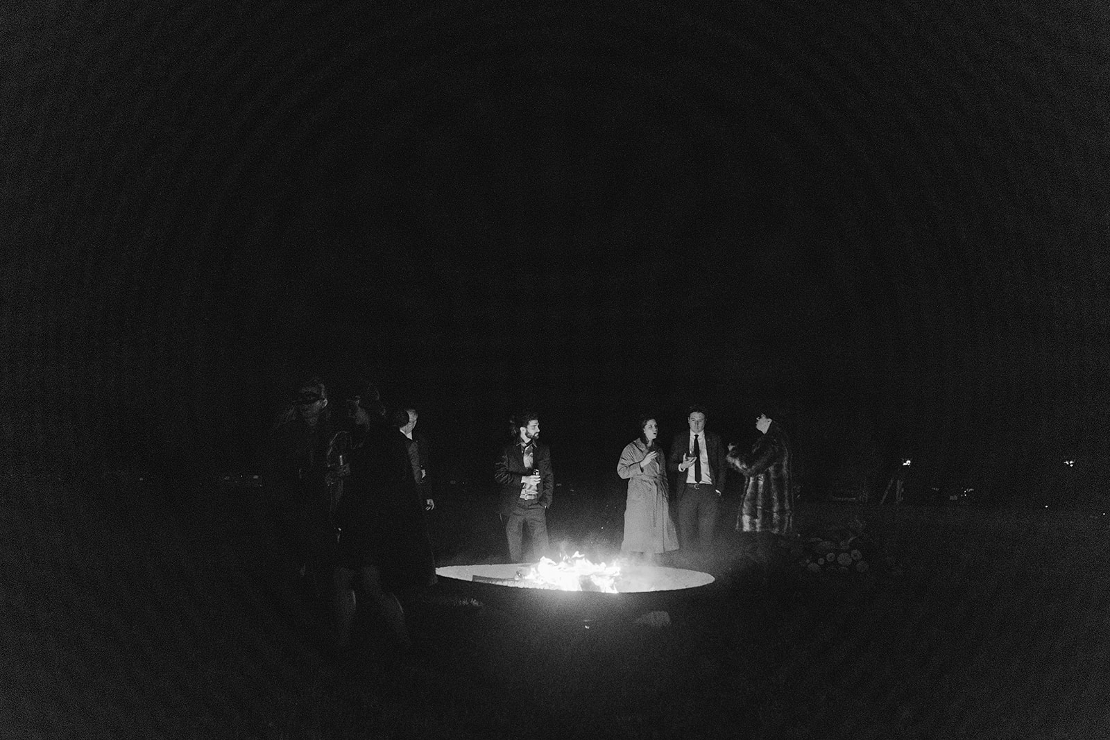 wedding guests stood around large bonfire at Halloween wedding reception
