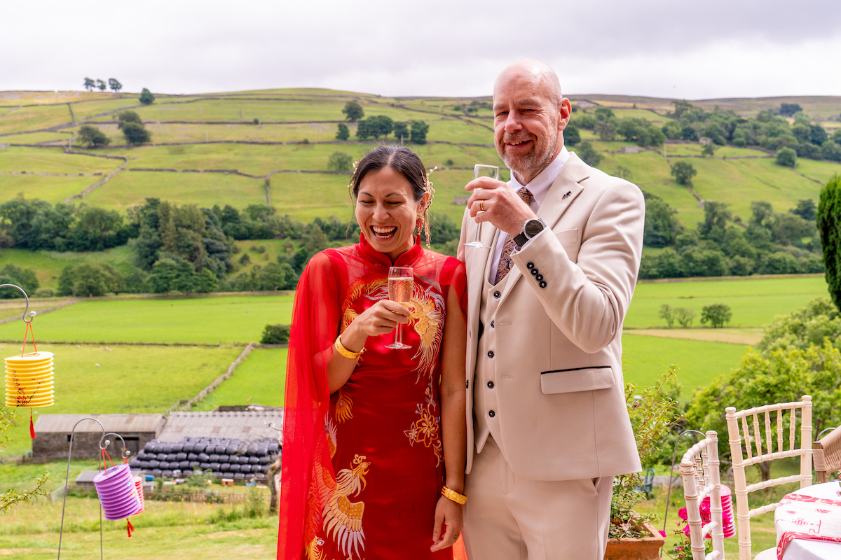 Bride and groom drinking champagne with Yorkshire hills in the background