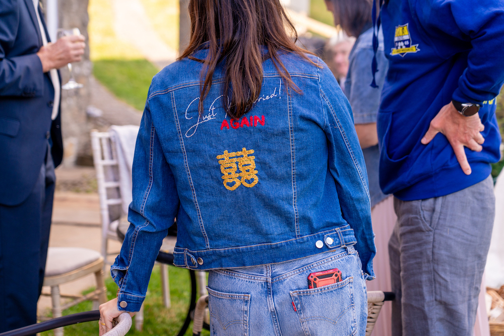 bride wearing denim jacket with just married again embroidered on the back