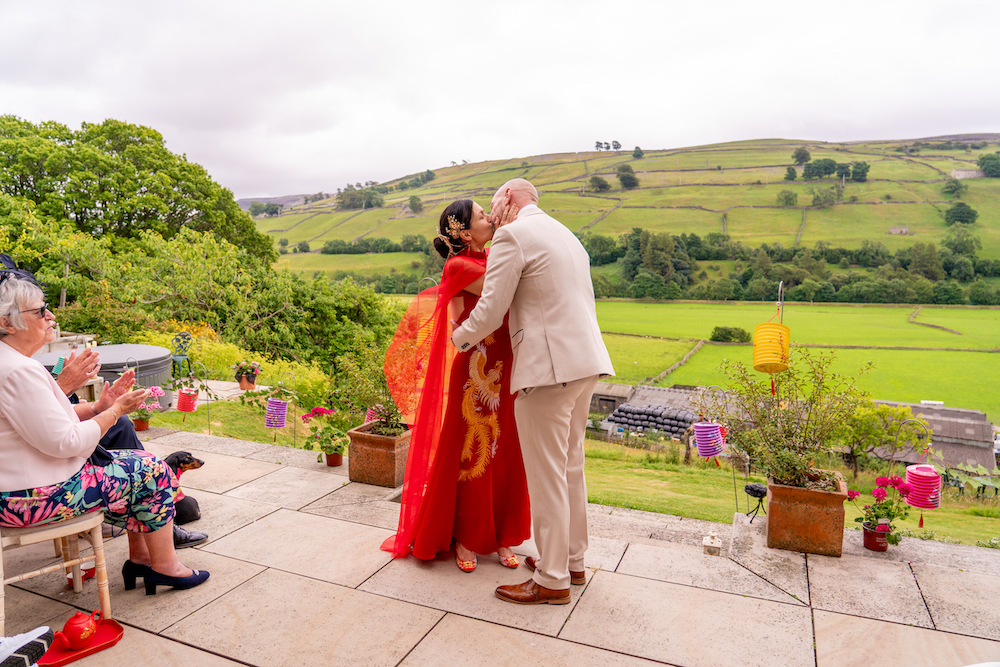 Bride and groom kiss at their Chinese-Texan-Bristish fusion wedding
