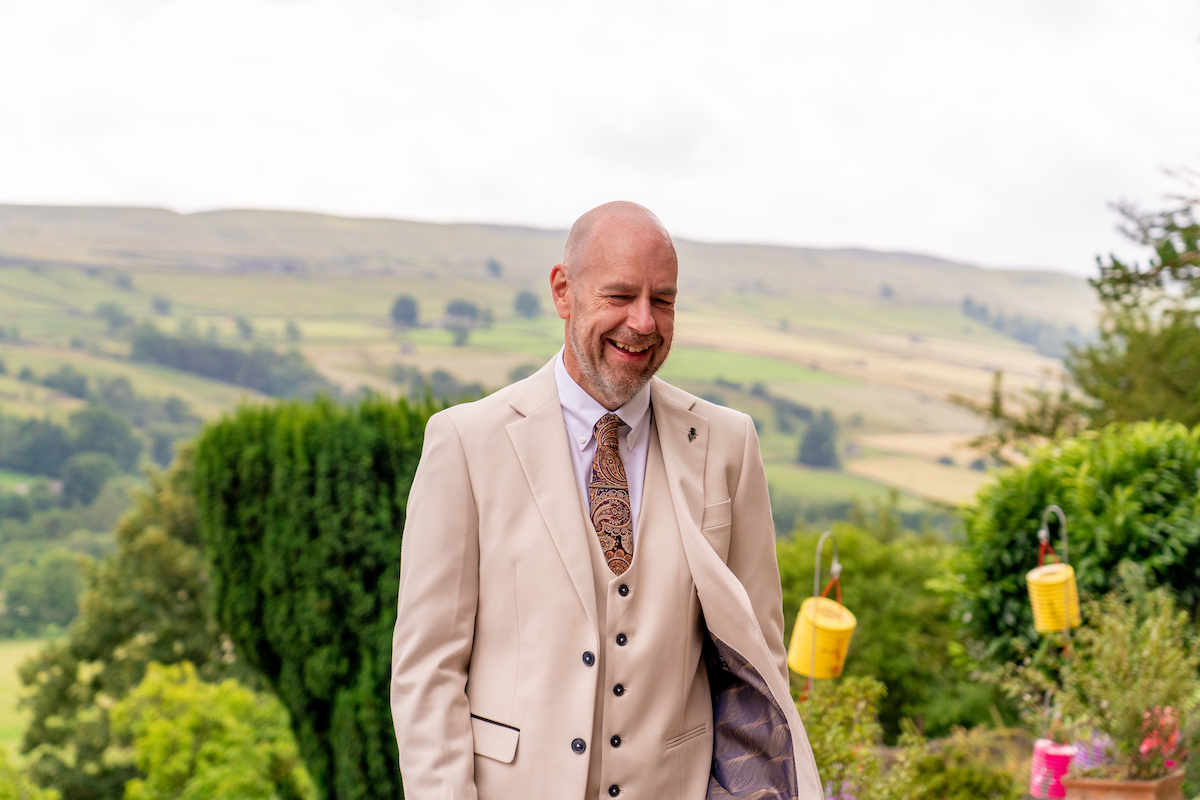 groom wearing cream three piece suit and tie for intimate fusion wedding in Yorkshire
