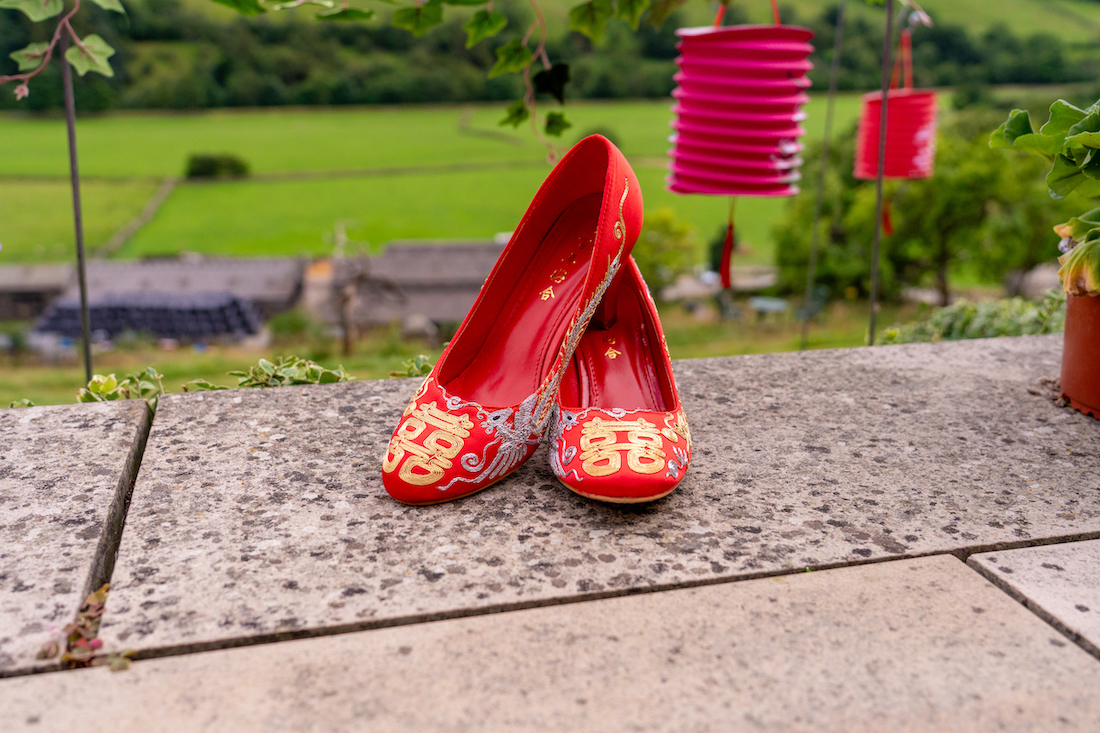 close up of Chinese red wedding shoes with gold Chinese symbols on them