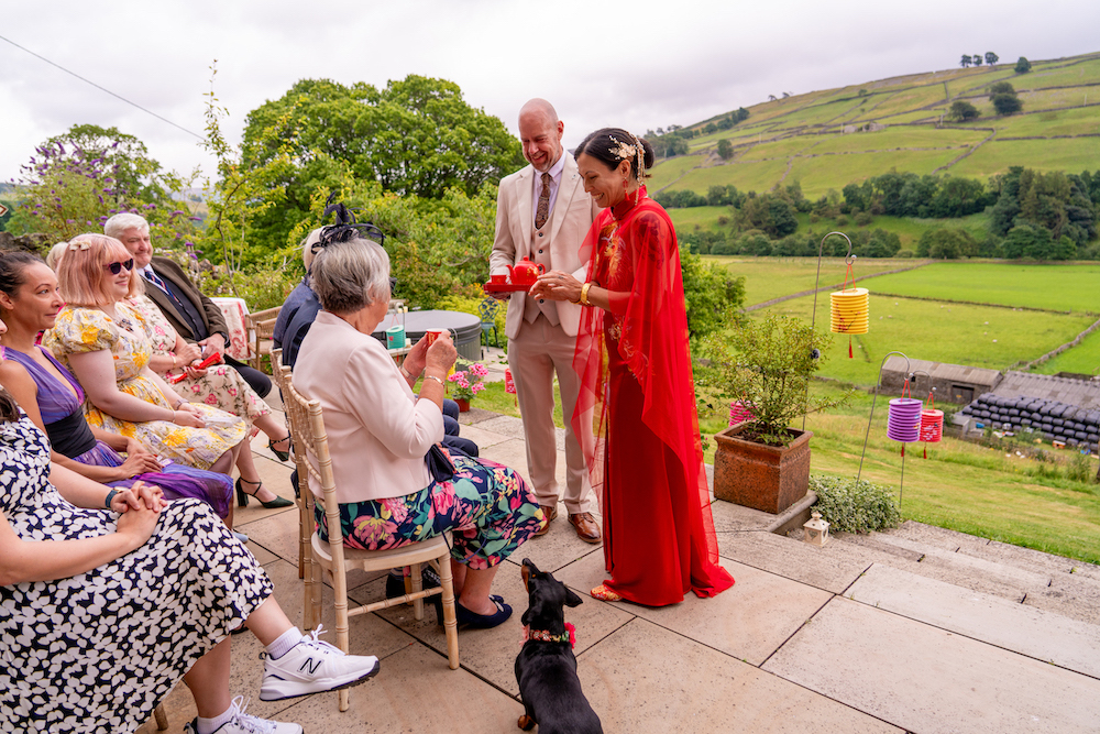 bride and groom serving tea as part of a traditional Chinese tea ceremony during the wedding ceremony